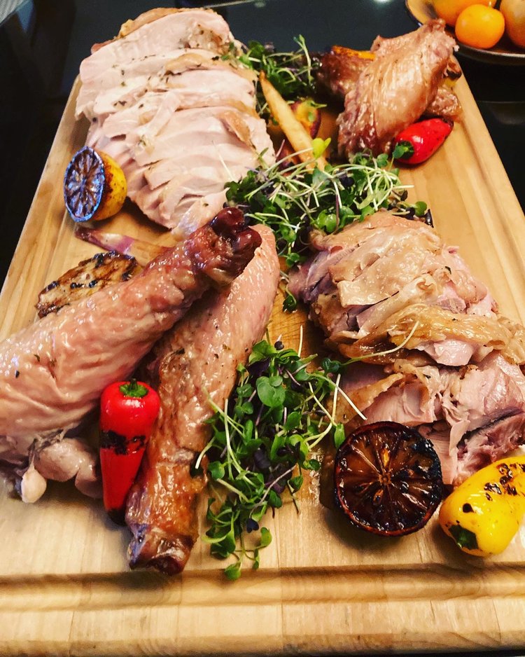 Carved meats and roasted vegetables plated on a board