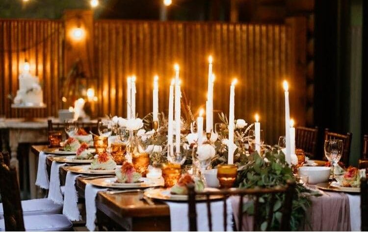 A long candlelit table set for a private gathering