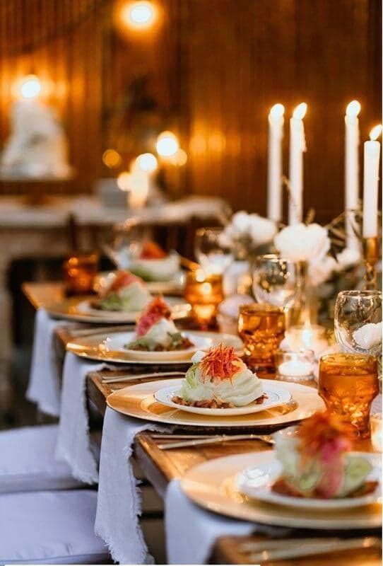 A candlelit table set with plated courses